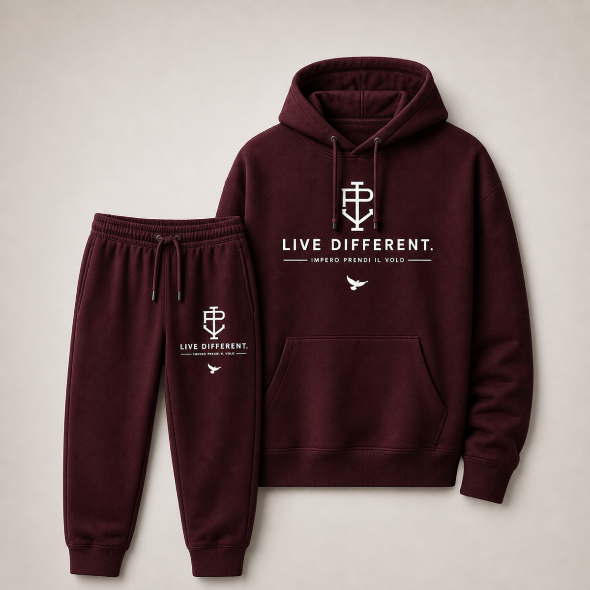A matching two-piece loungewear set consisting of a dark burgundy hoodie and jogger pants, both featuring white printed graphics and text on the front, displayed against a neutral beige background.